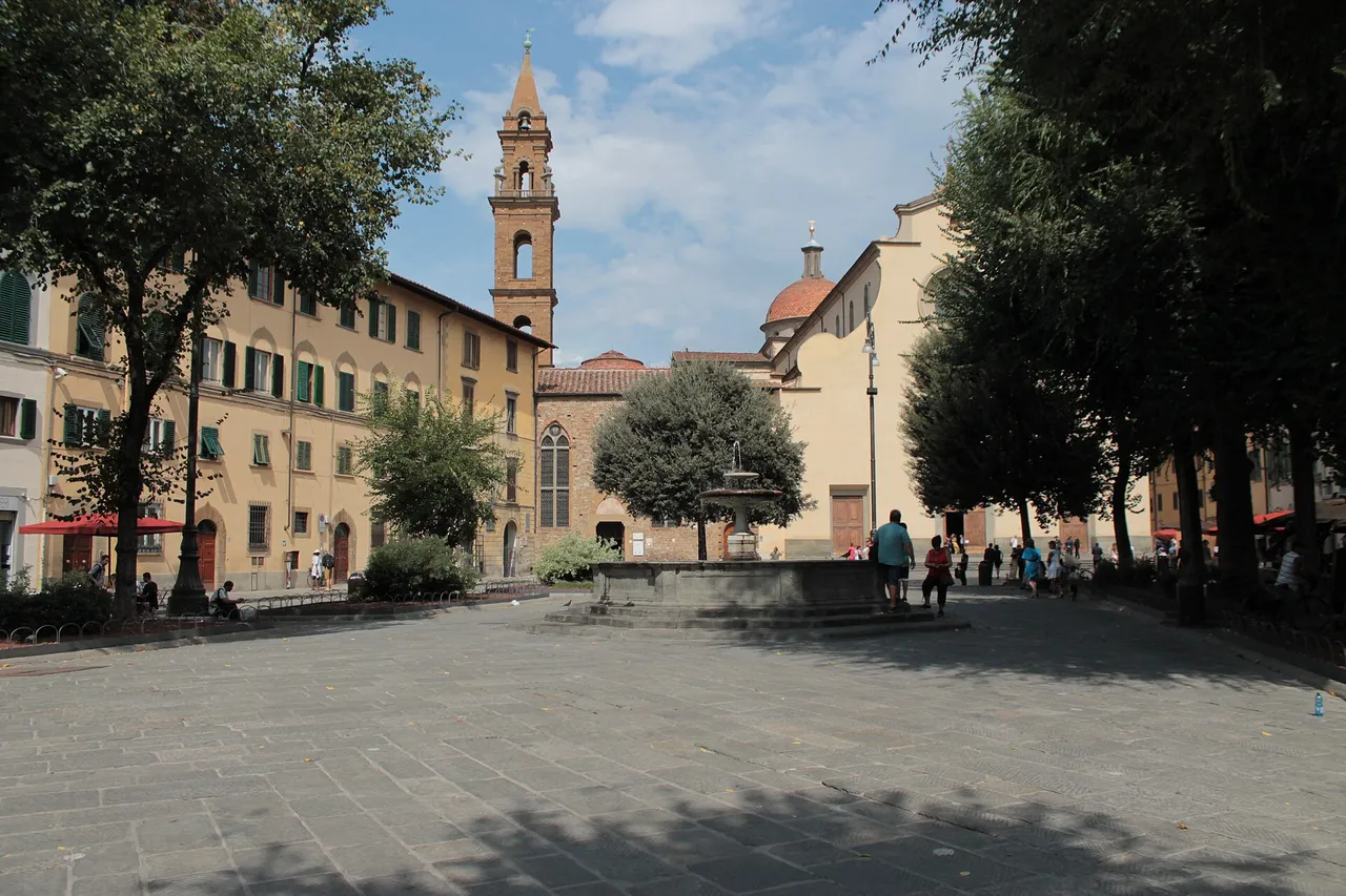Η Piazza Santo Spirito με δέντρα, σιντριβάνι και το καμπαναριό της βασιλικής